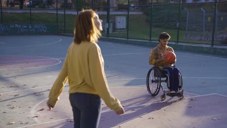 Friends-playing-basketball-on-basketball-court-outdoors.